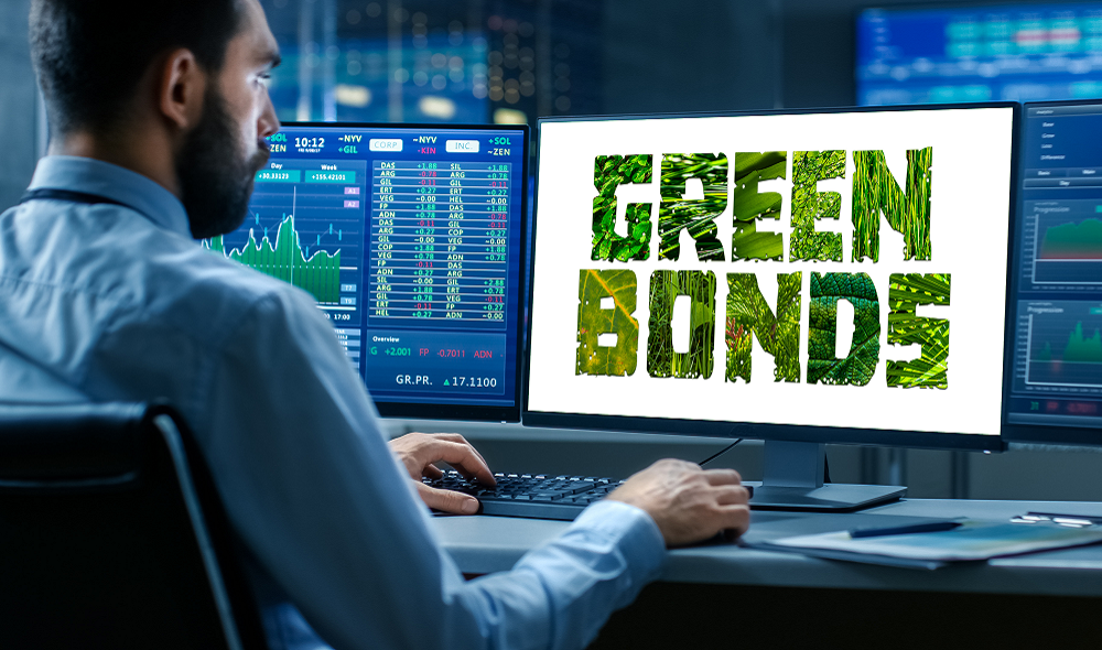 man achter een computer met op het scherm de tekst Green bonds